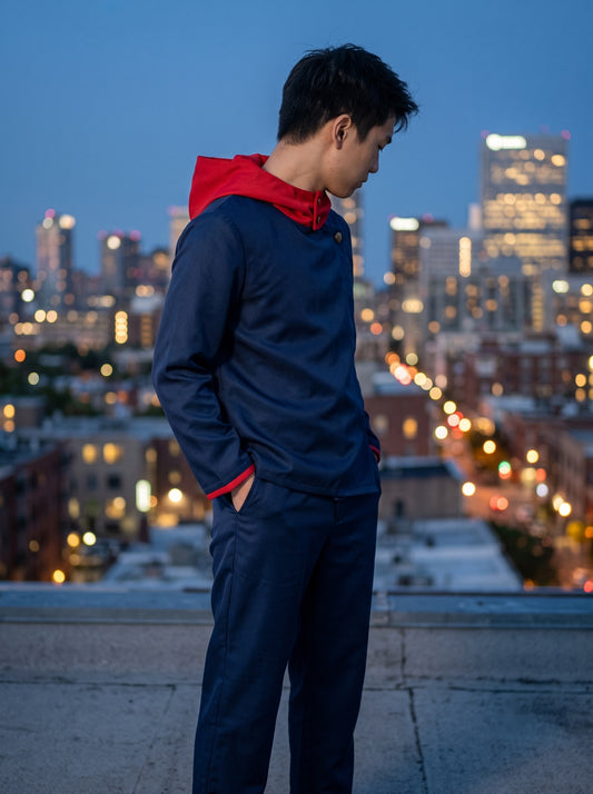 Navy hooded uniform set worn by model on rooftop at dusk
