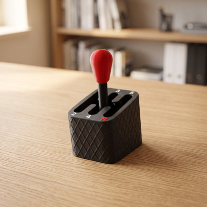 Manual gear shifter fidget toy with red knob standing on a light oak desk
