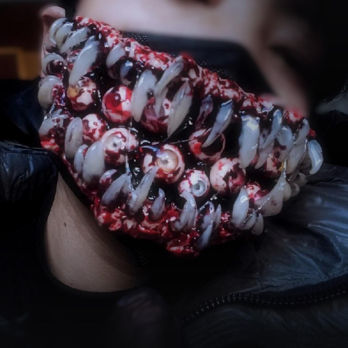 Monster fang mask under a black hood
