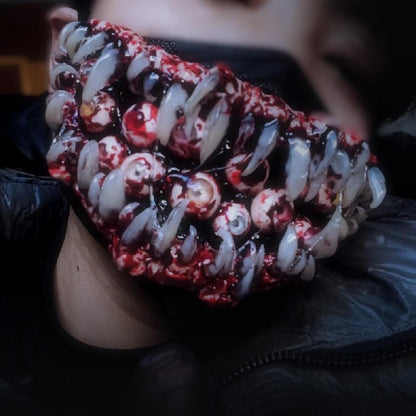 Monster fang mask under a black hood