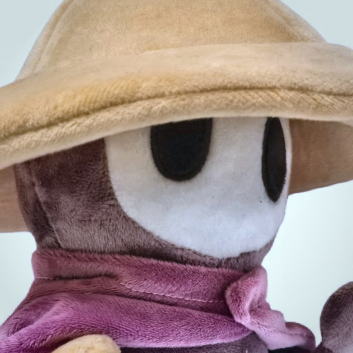 Close up of Sherma plush face under the straw hat brim