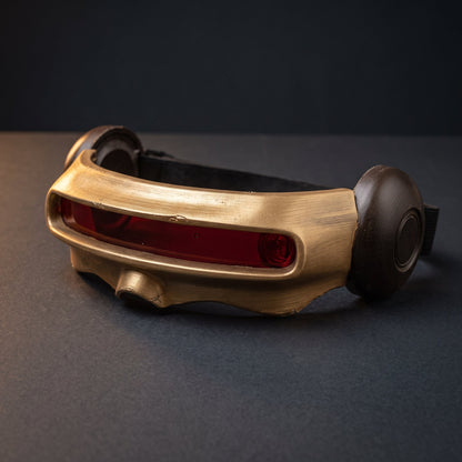 Gold visor from the front with the black elastic head strap visible behind it