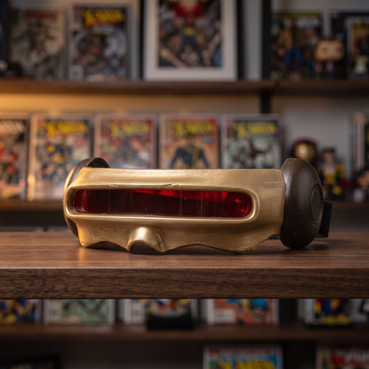 Gold visor displayed on a dark walnut shelf in a comic collector's room